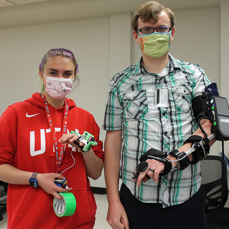 a pair of Price Engineering Ambassadors modeling bionic hands. external attachments to assist with hand usage