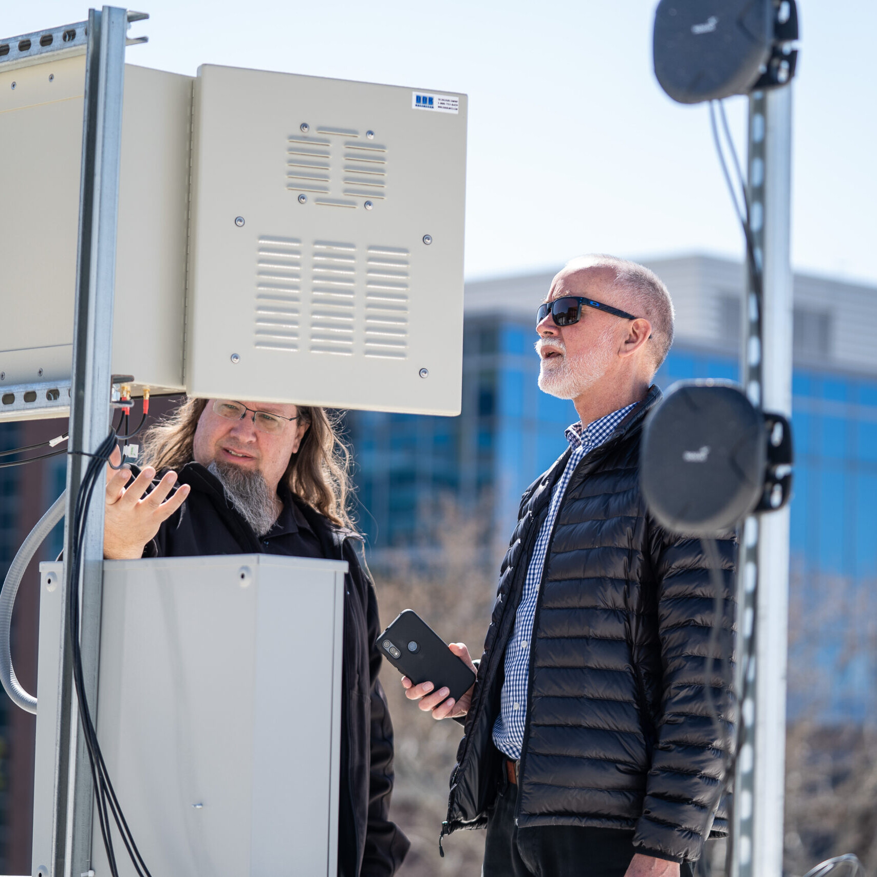 Kobus Van Der Merwe and Kirk Webb adjust wireless transmitters on a building roof