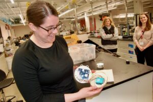 Tristalee Mangin shows off the circuitry of an atmospheric sensor